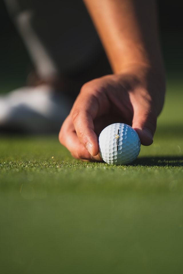 golf ball being placed on turf